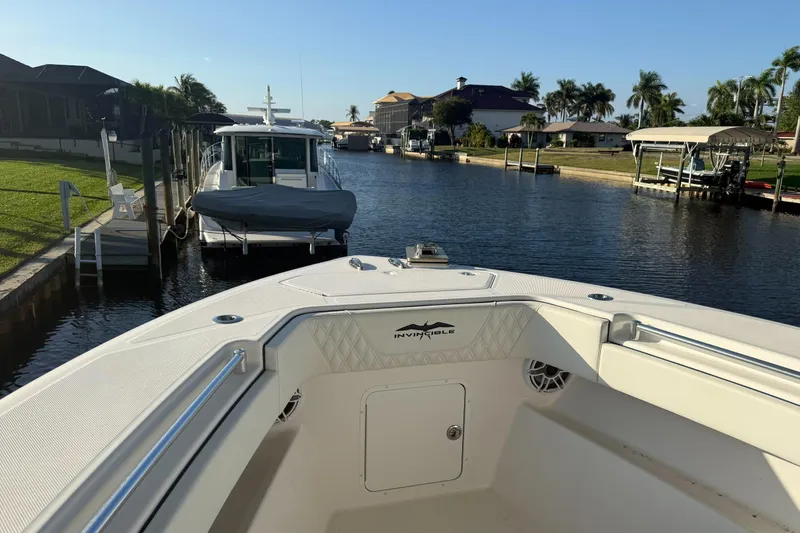 Slide: The Image of 2024 Invincible 39 Open Fisherman boat docked in a scenic canal setting. - 22