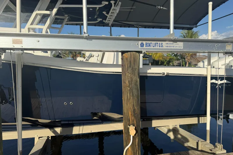 Slide: The Image of 2024 Invincible 39 Open Fisherman on boat lift, side view, sunny day. - 24