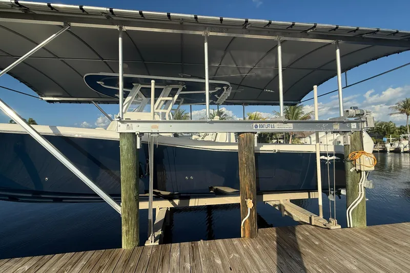 Slide: The Image of 2024 Invincible 39 Open Fisherman boat on lift, docked under canopy. - 28