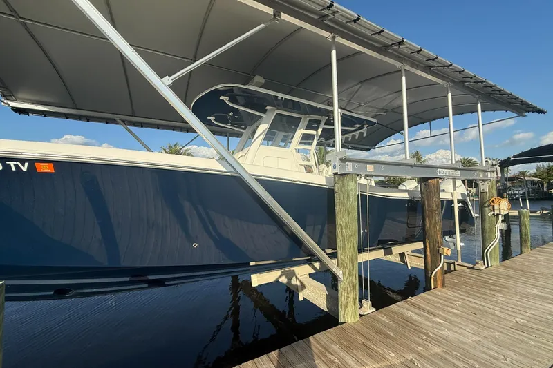 Slide: The Image of 2024 Invincible 39 Open Fisherman boat docked under a canopy. - 32