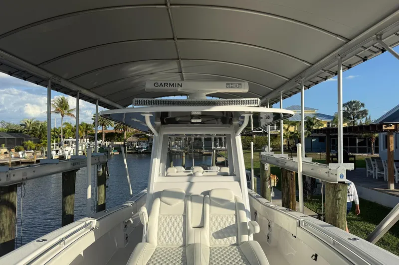 Slide: The Image of 2024 Invincible 39 Open Fisherman boat docked under canopy, featuring Garmin equipment. - 34