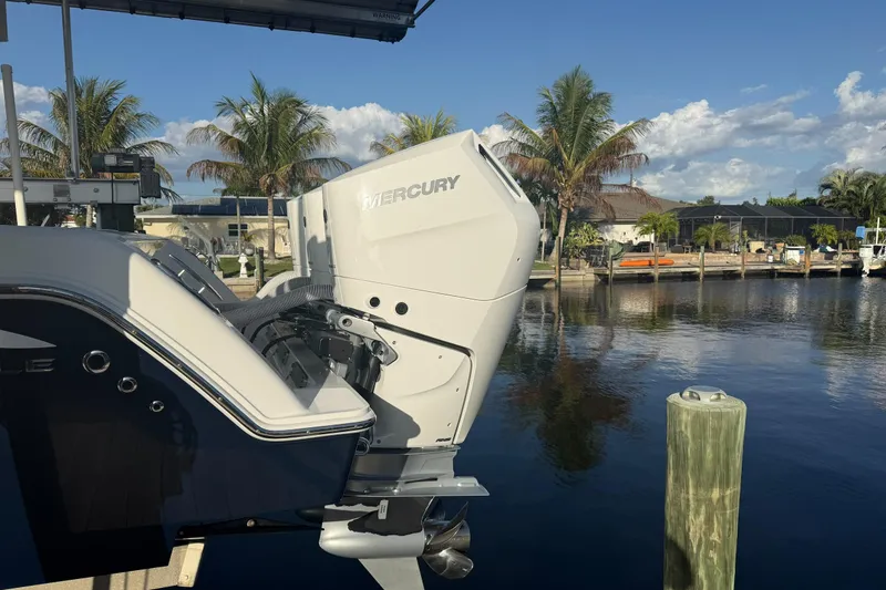 Slide: The Image of 2024 Invincible 39 Open Fisherman with Mercury engine docked by palm trees. - 35