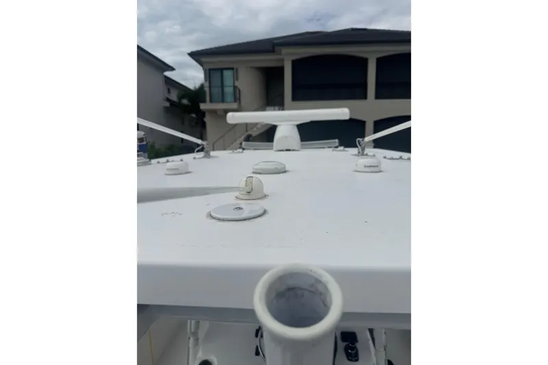 Slide: The Image of 2024 Invincible 39 Open Fisherman boat deck with equipment, residential background. - 7