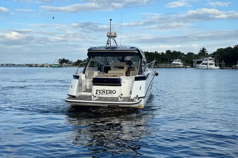 Slide: The Image of 2019 Beneteau Gran Turismo 40 yacht cruising on a calm waterway under a partly cloudy sky. - 12
