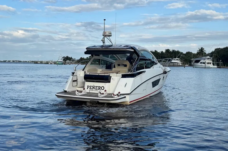 Slide: The Image of 2019 Beneteau Gran Turismo 40 yacht cruising on a calm waterway under a partly cloudy sky. - 14