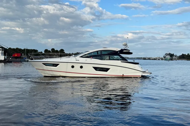 Slide: The Image of 2019 Beneteau Gran Turismo 40 yacht cruising on a calm, scenic waterway. - 6