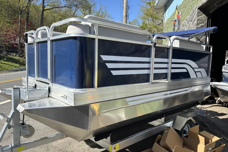 The Image of 2025 Pond-Tini Series 12 pontoon boat on trailer, featuring sleek blue and silver design. - 0