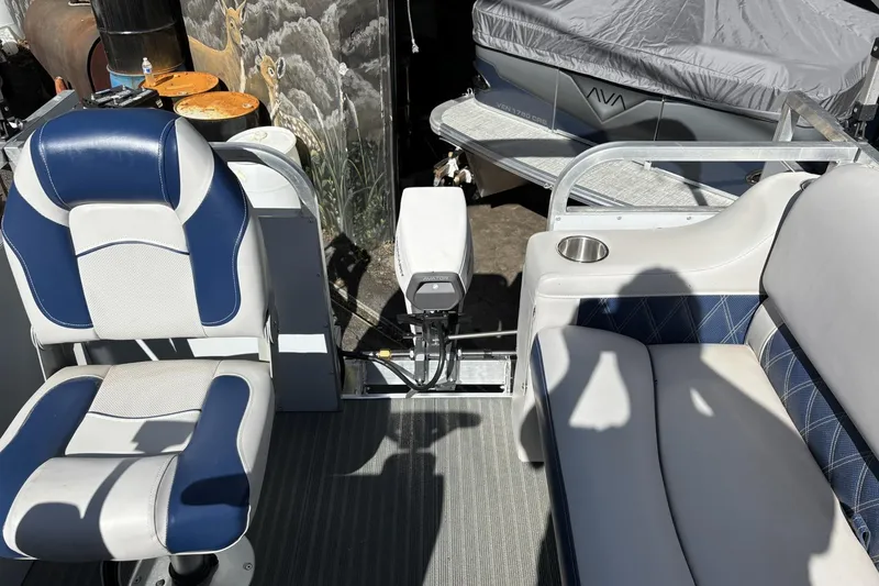 Slide: The Image of Interior of 2025 Pond-Tini Series 12 boat with blue and white seating. - 16