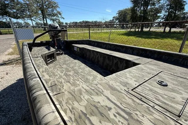 Slide: The Image of 2025 SeaArk 1752 Slayer Pro boat with camouflage design, parked outdoors. - 3