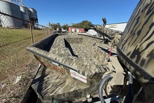 Slide: The Image of 2025 SeaArk 1752 Slayer Pro boat with camouflage design, parked outdoors. - 6