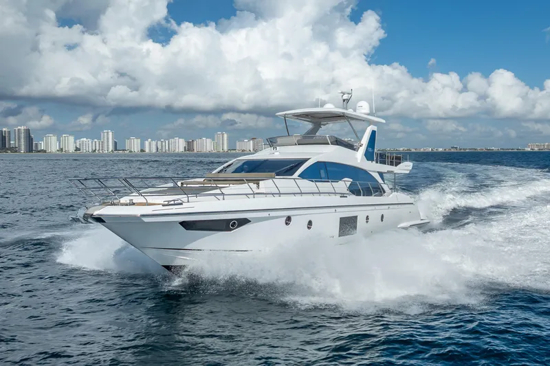 Slide: The Image of Luxurious 2019 Azimut 66 yacht cruising on open water with city skyline backdrop. - 15