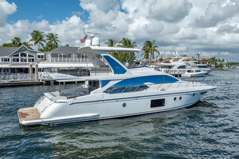 Slide: The Image of 2019 Azimut 66 yacht docked in a marina, surrounded by palm trees and buildings. - 22