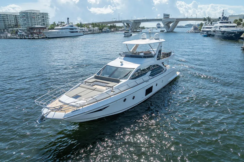 Slide: The Image of 2019 Azimut 66 yacht cruising in a sunny marina with bridge and buildings. - 27