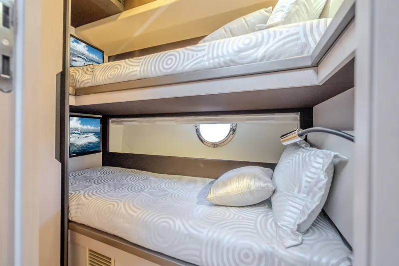 Slide: The Image of Bunk beds in 2019 Azimut 66 yacht cabin with circular window and patterned bedding. - 88