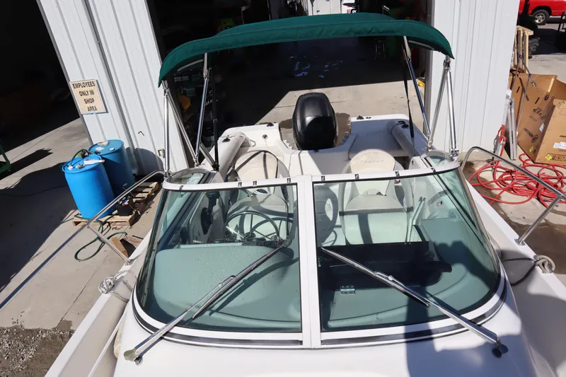 Slide: The Image of 2008 Trophy 2102 Walkaround boat with green canopy in a workshop setting. - 11
