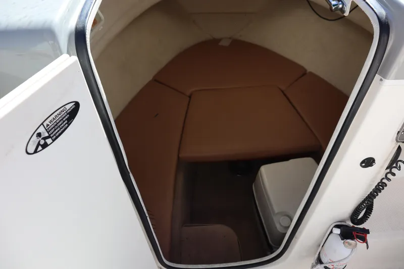 Slide: The Image of 2008 Trophy 2102 Walkaround cabin interior with brown cushions and safety equipment. - 5