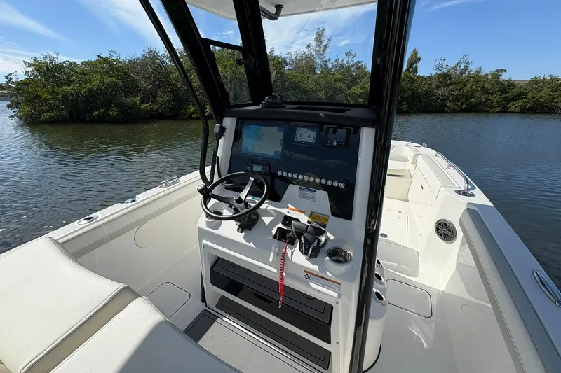 Slide: The Image of 2026 World Cat 235 TE boat interior with steering console on calm water. - 14