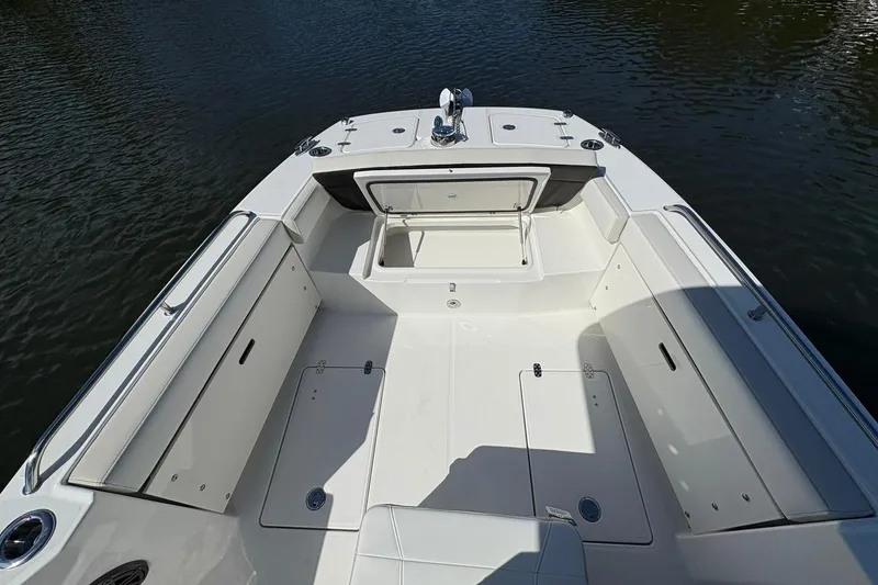 Slide: The Image of 2026 World Cat 235 TE boat interior with open storage compartment on calm water. - 17