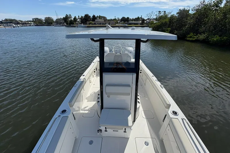 Slide: The Image of 2026 World Cat 235 TE boat on calm water, featuring sleek design and spacious deck. - 20