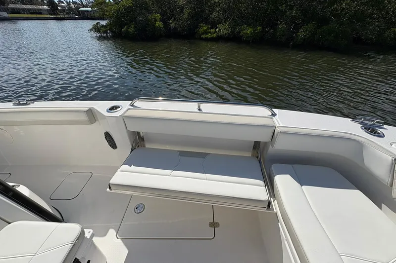 Slide: The Image of 2026 World Cat 235 TE boat interior with white seating, near calm water. - 21