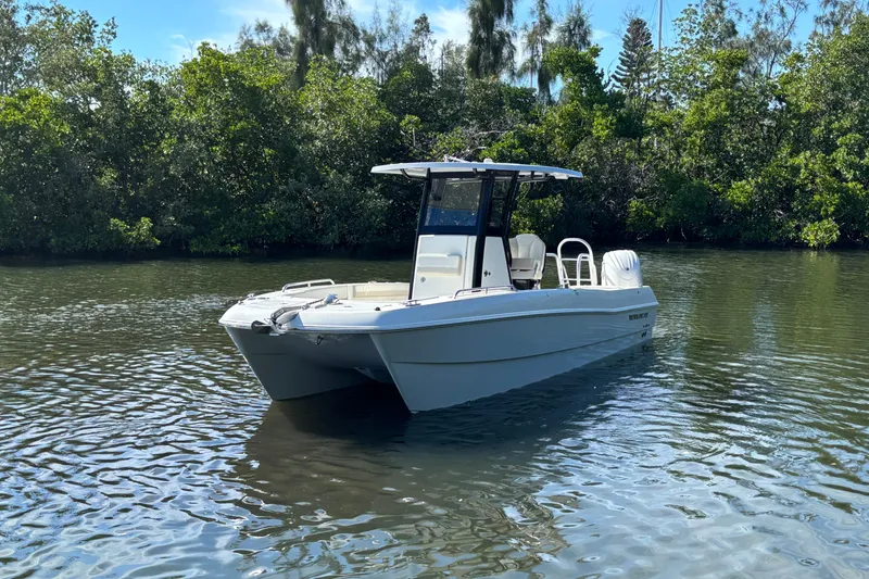 Slide: The Image of 2026 World Cat 235 TE boat on calm water, surrounded by lush greenery. - 3