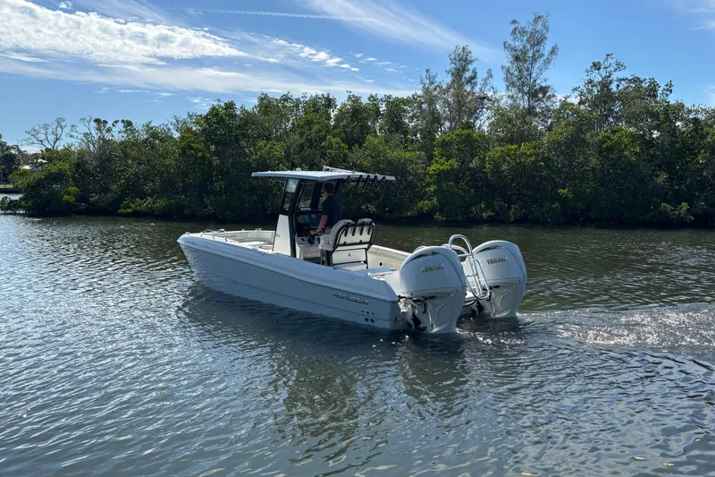 Slide: The Image of 2026 World Cat 235 TE boat cruising on a calm river with lush greenery. - 6