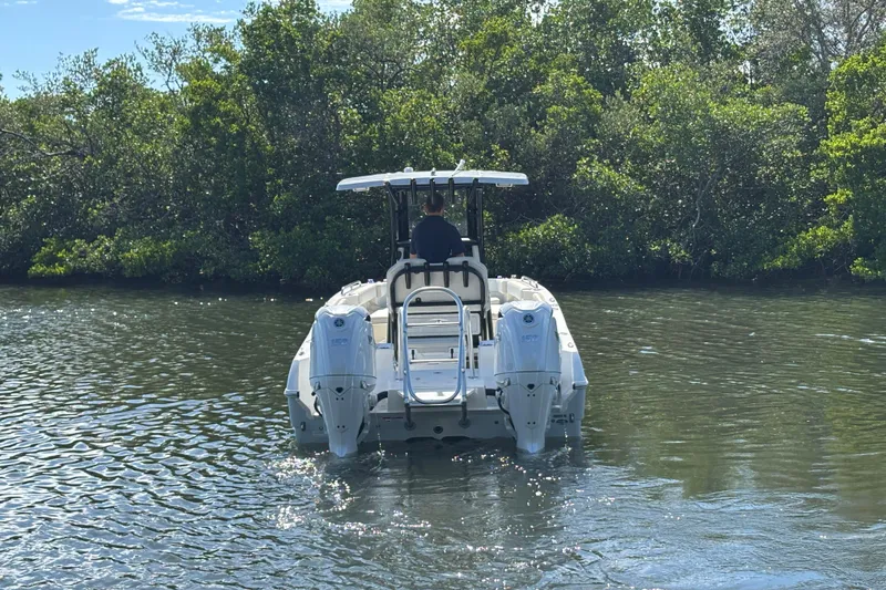 Slide: The Image of 2026 World Cat 235 TE boat navigating through calm waters near lush greenery. - 7