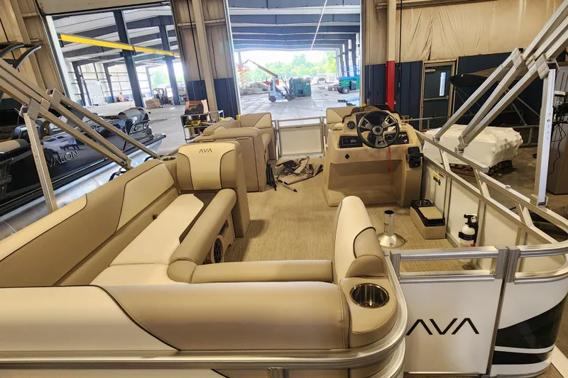 Slide: The Image of 2026 Avalon VENTURE CRUISE pontoon boat interior with beige seating and steering console. - 13