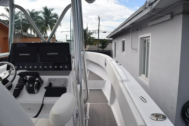 Slide: The Image of 1993 Fountain 27 Center Console boat with Garmin navigation, docked near a house. - 34