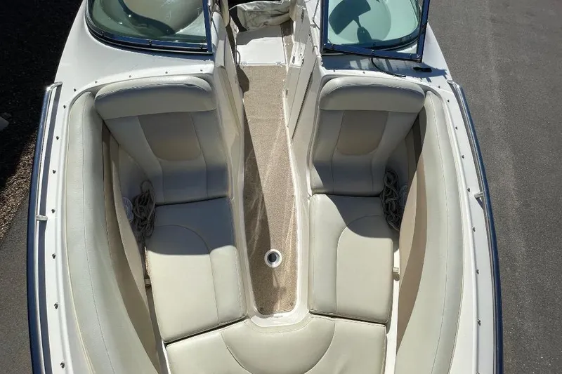 Slide: The Image of 2004 Chaparral 256 SSi boat interior with beige seating and open windshield. - 11