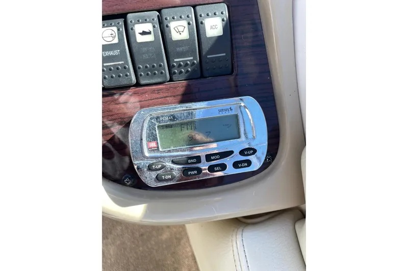 Slide: The Image of Control panel of a 2004 Chaparral 256 SSi boat with radio and switches. - 12