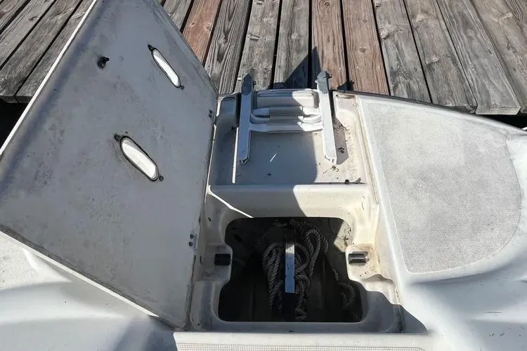 Slide: The Image of 2002 Four Winns 264 Funship boat storage compartment with open hatch near wooden dock. - 18