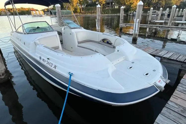Slide: The Image of 2002 Four Winns 264 Funship boat docked at a marina, featuring spacious seating and sleek design. - 2