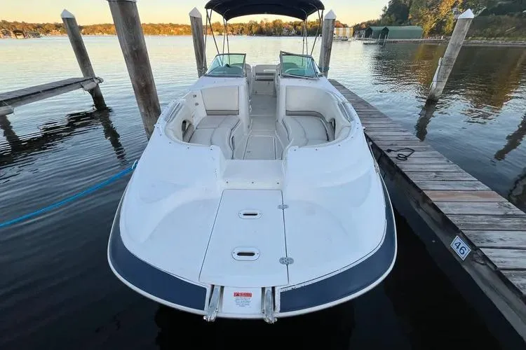 Slide: The Image of 2002 Four Winns 264 Funship boat docked on calm lake waters. - 3