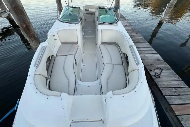 Slide: The Image of 2002 Four Winns 264 Funship boat with spacious seating, docked on calm water. - 4