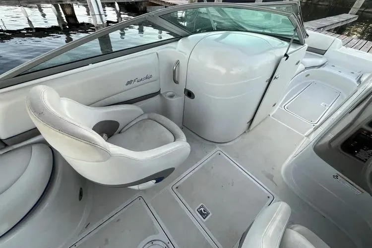 Slide: The Image of 2002 Four Winns 264 Funship boat interior with white seating and helm, dockside view. - 8