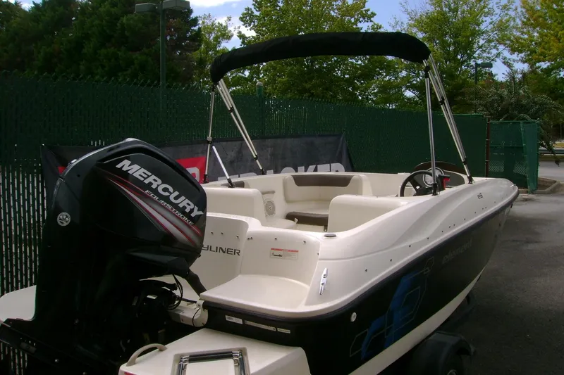 Slide: The Image of 2019 Bayliner Element E16 boat with Mercury outboard motor, parked outdoors. - 1