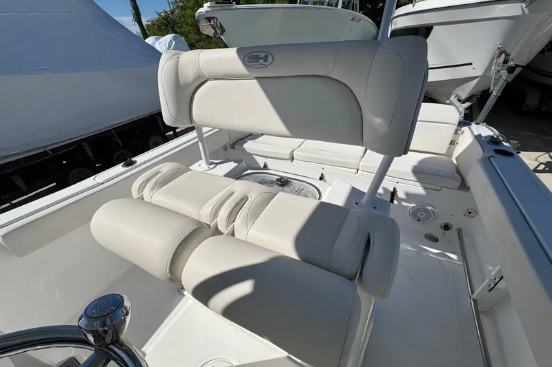 Slide: The Image of 2023 Sea Hunt Ultra 229 boat interior with cushioned seating and steering wheel. - 10