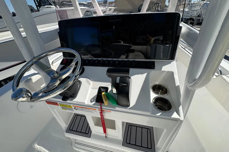 Slide: The Image of 2023 Sea Hunt Ultra 229 boat console with steering wheel and controls. - 12