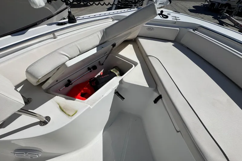 Slide: The Image of 2023 Sea Hunt Ultra 229 boat interior with open storage compartment and seating. - 18