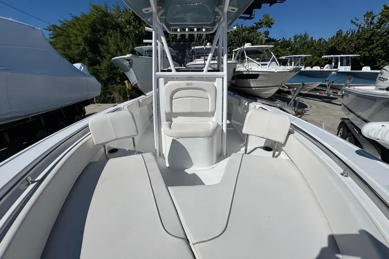Slide: The Image of 2023 Sea Hunt Ultra 229 boat interior with seating, parked among other boats. - 20