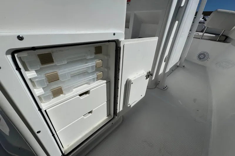 Slide: The Image of Storage compartment on 2023 Sea Hunt Ultra 229 boat, featuring organized tackle boxes. - 22