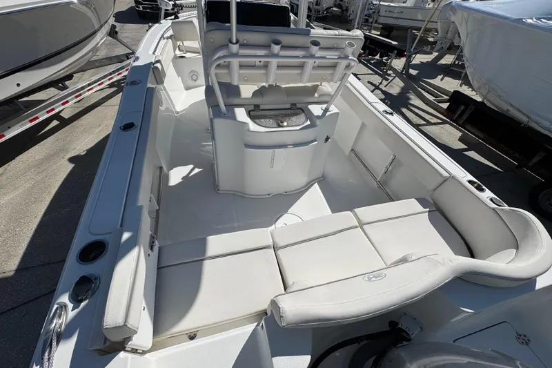 Slide: The Image of 2023 Sea Hunt Ultra 229 boat interior with seating and console, docked outdoors. - 3