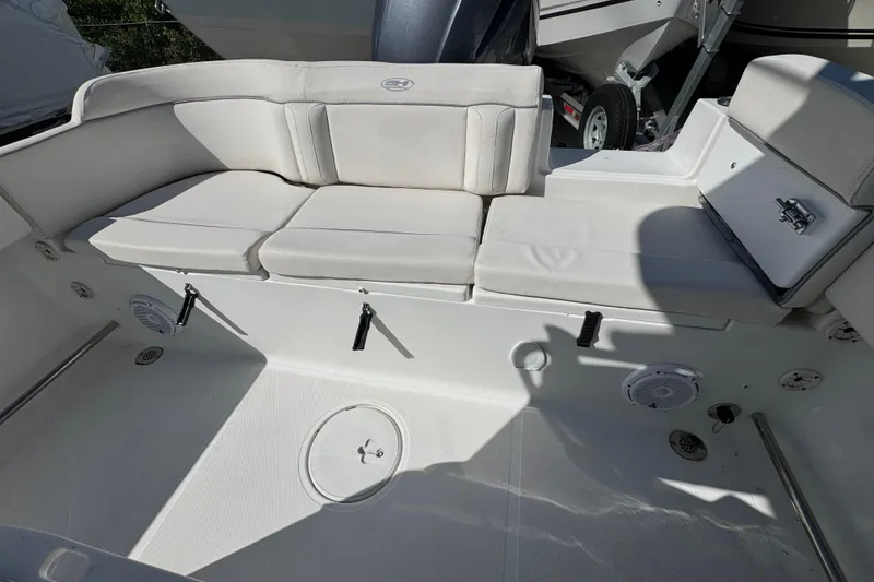 Slide: The Image of 2023 Sea Hunt Ultra 229 boat interior with white cushioned seating and storage compartments. - 4