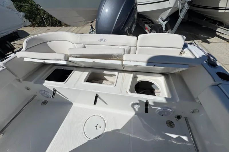 Slide: The Image of 2023 Sea Hunt Ultra 229 boat interior with open storage compartments and seating. - 6