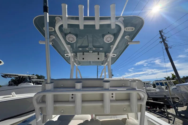 Slide: The Image of 2023 Sea Hunt Ultra 229 boat with T-top and rod holders under a clear blue sky. - 9