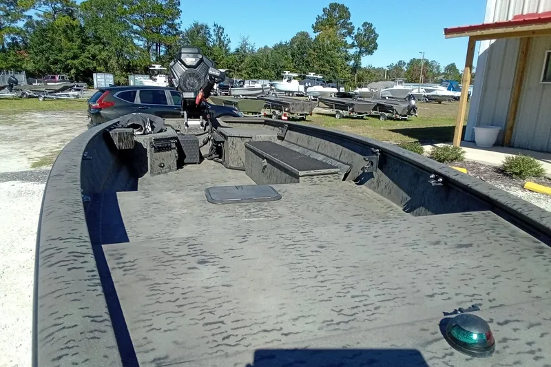 Slide: The Image of 2020 War Eagle 750 Gladiator boat with open deck, parked outdoors near other boats. - 11