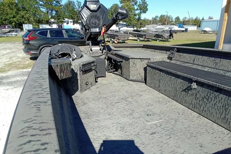 Slide: The Image of 2020 War Eagle 750 Gladiator boat interior with camo design, parked outdoors. - 13