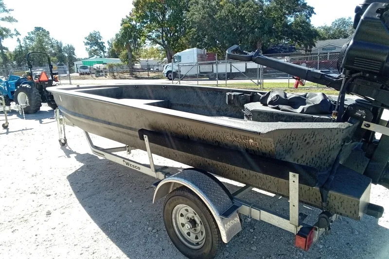 Slide: The Image of 2020 War Eagle 750 Gladiator boat on trailer, parked outdoors. - 21