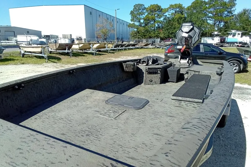 Slide: The Image of 2020 War Eagle 750 Gladiator boat in outdoor storage, surrounded by trailers and vehicles. - 24